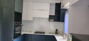 KingsmeadLovely 3 bed in Mount Pleasant - 2153的厨房配有白色橱柜和蓝色柜台。