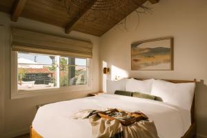 拉古纳海滩Sonder Woods Cove的卧室配有一张大白色床和窗户