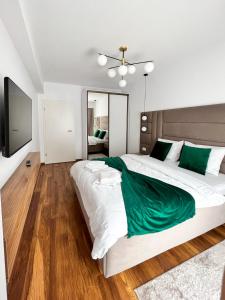 布拉索夫Alegria Avantgarden Brasov的卧室配有带绿色床单的大型白色床