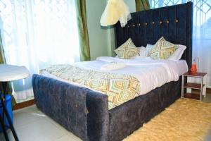 KakamegaUrban Oasis的一间卧室配有一张大床和蓝色床头板