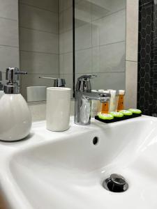 布拉索夫Alegria Avantgarden Brasov的白色浴室水槽,配有镜子和水槽
