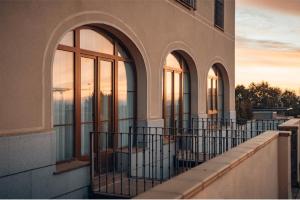 塞哥维亚坎迪多酒店的一座带拱门和窗户的阳台建筑