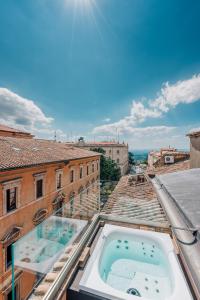 佩鲁贾Locanda della Posta Boutique Hotel的从带热水浴池的建筑屋顶上可欣赏到风景