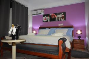 杜阿拉Polgaro duplex luxueux的一间卧室设有一张紫色墙壁的大床