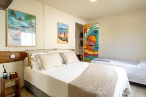 里约热内卢Longboard Paradise Suítes的卧室设有一张白色大床和一扇窗户。