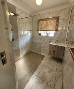 波罗瓜尼29B Zebra Street - InHimwe Guesthouse的带淋浴和盥洗盆的浴室