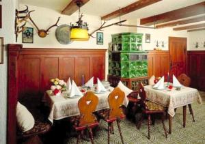 克舍尔Landhotel Herzogstand Garni的一间用餐室,在房间内配有两张桌子和椅子