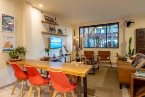 里约热内卢Longboard Paradise Suítes的客厅配有木桌和橙色椅子