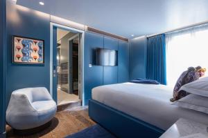 伦敦Sun Street Hotel Shoreditch的蓝色卧室,配有床和椅子