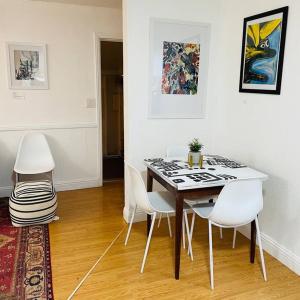 萨克拉门托Artist's retreat near the heart of the city的一间带桌子和白色椅子的用餐室