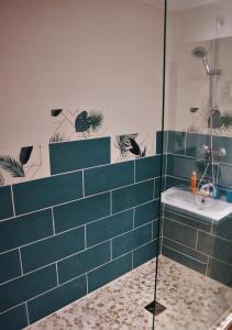 加普La lanterne的蓝色瓷砖浴室配有淋浴和盥洗盆