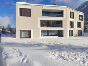 达沃斯Apartment Seewiesenstrasse by Interhome的雪地里的房子,雪地里留下脚印