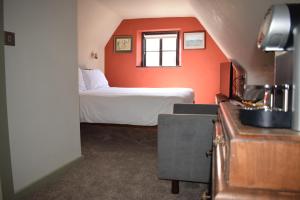 哈里奇Alma Inn & Dining Rooms的一间卧室设有橙色墙壁和床