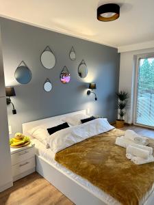 新松奇Beskid Apartamenty的卧室配有一张大床,墙上装有镜子