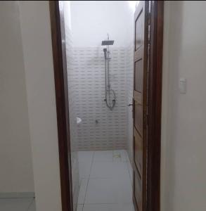 圣路易斯Salam的带淋浴的浴室和白色瓷砖地板。