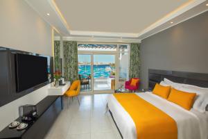 沙姆沙伊赫Naama Bay Suites & SPA的一间卧室配有一张大床和电视