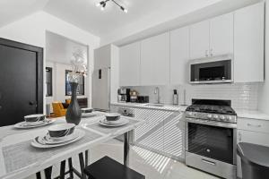 布鲁克林Cozy 3BR Brooklyn Artisan Loft的厨房配有桌子和炉灶。 顶部烤箱