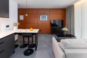 瓦伦西亚Calatrava by Alma Suites的厨房以及带桌子和沙发的客厅。