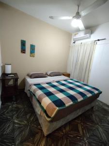 波萨达斯Como en casa Hostel的一间卧室配有一张带 ⁇ 子毯子的床