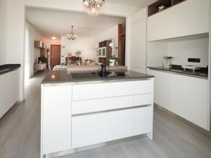 勒威诺Apartment Marì by Interhome的厨房配有白色橱柜和水槽