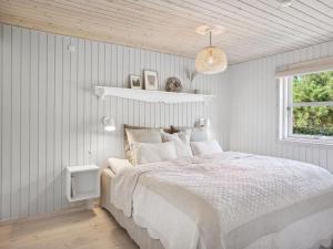 布洛克胡斯Holiday Home Ofelia - 2-5km from the sea in NW Jutland by Interhome的白色的卧室设有床和窗户