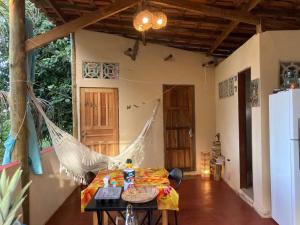 伊塔卡雷Casa Vila Camboinha的一间设有吊床的客房,位于带桌子的房子里