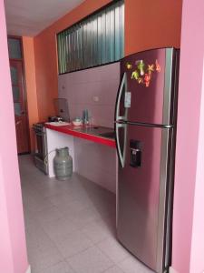 莫约班巴D202的厨房配有不锈钢冰箱和橙色墙壁