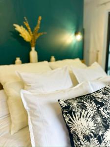 勒唐蓬La Parenthèse chez Seb et Gwen的一张带白色枕头和绿色墙壁的床