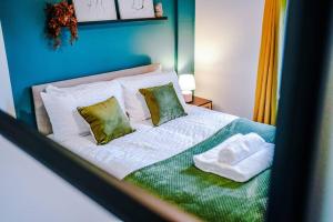 KnowsthorpeSpacious 3br close to centre with parking的一间卧室配有带白色床单和绿色枕头的床。
