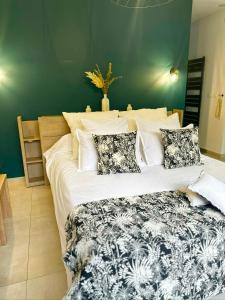 勒唐蓬La Parenthèse chez Seb et Gwen的卧室配有一张带白色床单和枕头的大床。