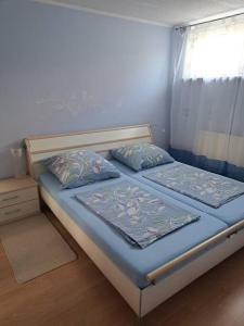 菲尔特Schöne 2 Zimmer Wohnung的一间卧室设有两张带蓝色床单的床和窗户。