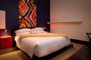 查塔努加Hotel Clemons的卧室配有一张白色大床,墙上挂有绘画作品