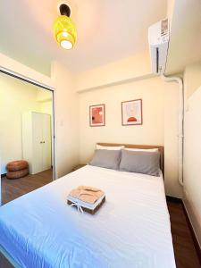 马尼拉1BR Prisma Residences DMCI Stylish Condo的客房设有一张带风扇的大床。