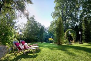 米特西尔Hotel Schloss Mittersill的两把椅子坐在院子里的草坪上