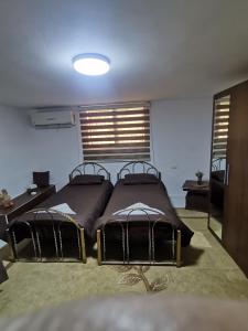乌姆盖斯Beit Al Hasan بيت الحسن的一间卧室设有两张床、一张桌子和窗户。