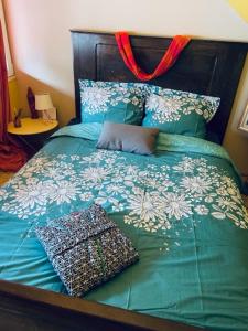 伊尔基希-格拉芬斯塔登SousmonToi的一张带绿色棉被和枕头的床