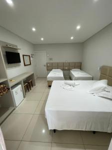 佩尼亚Pousada Augusta的酒店客房设有两张床和电视。