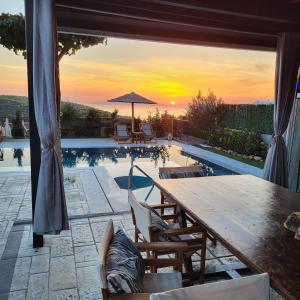 阿纳维索斯Stergiou Luxury Apartments with shared pool的一个带木桌和游泳池的庭院