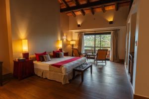 伊瓜苏港伊瓜苏套房酒店的一间卧室配有一张带红色枕头的大床