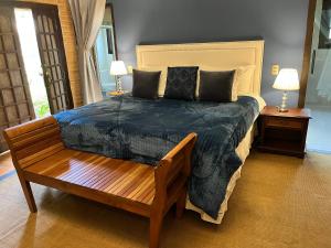 蒙特韦尔迪Pousada Dona Bendita的一间卧室设有一张大床和一张木凳