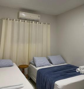 圣米格尔-杜戈斯托苏Gostoso Maresia Flats的一间卧室配有两张床和空调。