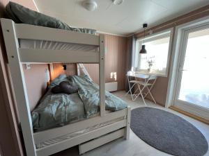 特罗姆瑟Room in Tromsø, Kvaløya的配有书桌的小客房内的双层床