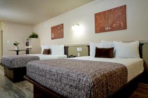 拉雷多家庭花园客栈及套房酒店的一间酒店客房,房间内设有两张床