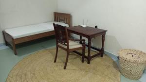 拉穆Manama Suites Lamu的一间卧室配有书桌、一张床、一张桌子和椅子