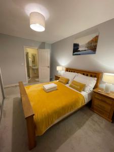 卡迪夫Holiday Home In Cardiff, Sleeps 8的一间卧室配有一张带黄色毯子的大床