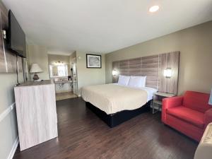 桑蒂Travelodge by Wyndham Santee的酒店客房,配有一张床和一张红色椅子