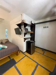 塔马林多Casa del Sol的小房间,设有床和带有手 ⁇ 标志的墙壁