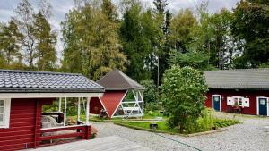 AsphyttanHöga Backe Gästhus的两座红色的建筑,在院子里有一个凉亭