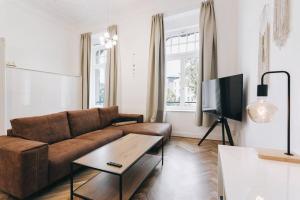 德累斯顿TIP! Geräumiges Apartment direkt im Stadtzentrum für 6 Personen的客厅配有棕色沙发和电视