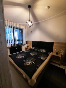 斯诺科Aparthouse Zegrze的一间卧室配有一张带黑色棉被的床